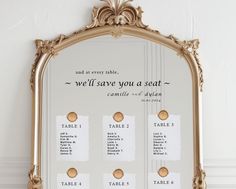 a gold framed mirror with seating cards attached to the front and back of each frame