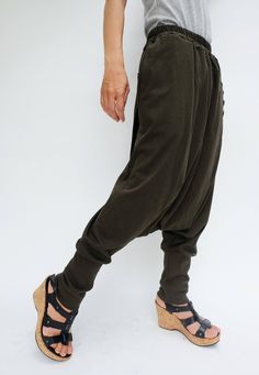 "🚚..ALL ORDERS ARE SHIPPED VIA DHL EXPRESS MAIL Relaxed fit dropped-crotch pants in olive. Asymmetric crossover fabric panel at front and back with 3 buttons front detailed. Elastic waistband and two hand pockets at side seam. Roll up the cuffed hem for an utlra relaxed look! * Pull-on style * Drop-crotch style * 2\" Elastic waistband * Side seam pockets * Wide cuffed hem Measurements approximately: Waist : 26\" (66 cm) stretching to 48\" (122 cm)-elastic material Hips : 50\" (122 cm) Outseam: Button-detail Loungewear Pants, Baggy Khaki Pants For Loungewear, Cotton Bottoms With Buttons For Loungewear, High Waist Baggy Khaki Harem Pants, Baggy High Waist Khaki Harem Pants, Casual Baggy Drop Crotch Yoga Pants, Casual Fitted Harem Pants With Tapered Leg, Relaxed Fit Loungewear Bottoms With Buttons, Khaki Relaxed Fit Harem Pants For Fall