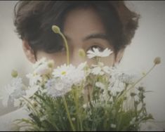 a woman holding flowers in front of her face