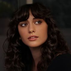 a woman with long dark hair wearing a necklace