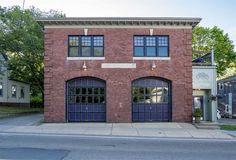 an old brick building with two garages on the front and one above it's doors