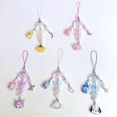 several charms are hanging on a white surface