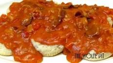 a white plate topped with bread covered in red sauce and meat on top of it