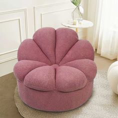 a pink flower shaped chair sitting on top of a rug