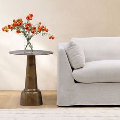 a living room with a couch, table and flowers on the floor in front of it