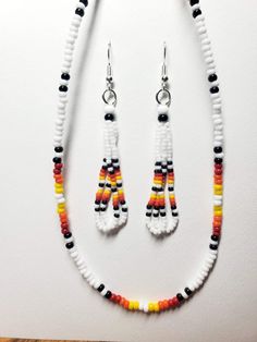 Native beaded Dangle White Fire earrings and Necklace. Necklace is 24 in with the expandable chain clasp. I use real Czech glass seed beads. All my items are handmade by me a proud Member of the Chippewa Tribe of Turtle Mountain. Beaded Earrings With Round Beads For Gifts, Orange Jewelry With Tiny Beads For Crafting, Heishi Beads Jewelry With Dangling Beads As Gift, Handmade Heishi Bead Dangle Jewelry, Handmade Orange Heishi Beads Jewelry, Adjustable Hand-strung Beaded Earrings, Adjustable White Beaded Earrings With Spacer Beads, White Czech Glass Beaded Dangle Earrings, Colorful Heishi Beads Dangle Jewelry