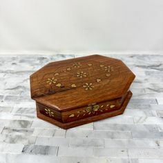 a small wooden box sitting on top of a white tiled floor next to a wall