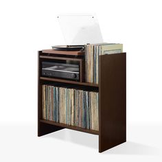 an old record player is sitting on top of a shelf with records and cassettes