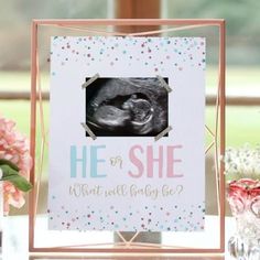 a baby announcement with a photo frame and confetti on the table next to it