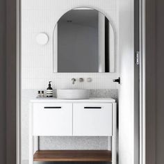 a bathroom with a sink, mirror and wooden stool in front of the door that leads to another room