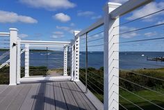 an empty deck overlooking the ocean on a sunny day with blue skies and white clouds