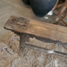 a wooden bench sitting on top of a rug