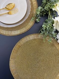 two plates with gold rims and flowers on the table next to eachother