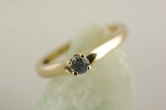 a yellow gold ring with a blue diamond