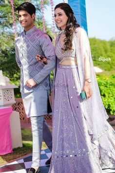 a man and woman standing next to each other on a checkered floor with decorations