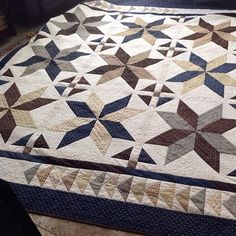 a quilt is laying on the floor next to a chair