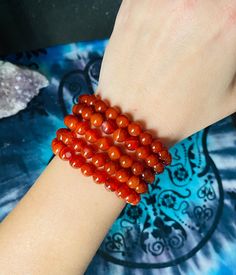 Bracelet made with 8mm Carnelian beads on a stretchy string. Easy to go on and take off any size wrist.  Beautiful and vibrant red orange coloring on every bead.  *Selenite Tower is for display use only. Not included in purchase.  *Not every bead is the same.  Each stone has it's own unique look (size, shape, coloring).  Carnelian is good for motivation for success, stimulating creativity, promoting positive life choices, restoring vitality.  Associates well with Sacral and Root Chakras. Orange Gemstone Beaded Bracelets For Meditation, Orange Spiritual Stretch Bracelet Hand-strung, Spiritual Orange Hand-strung Stretch Bracelet, Selenite Tower, Carnelian Bracelet, Chesapeake Va, Carnelian Beads, Life Choices, Positive Life