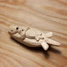 a small wooden turtle sitting on top of a wooden table next to a piece of wood