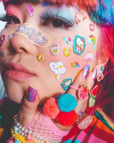 a woman with colorful hair and makeup has her face covered by stickers on her face