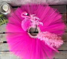 a pink flamingo tutule and candle on a wooden table