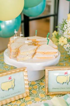 there is a cake on the table and balloons in the air behind it with little pins stuck to them