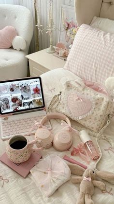 a laptop computer sitting on top of a bed next to stuffed animals and other items