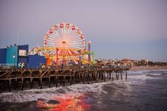 an amusement park with a ferris wheel on the beach