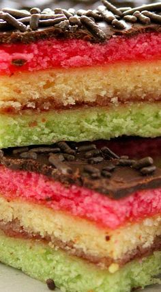 three different colored desserts stacked on top of each other with chocolate and raspberry filling