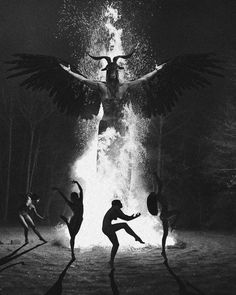 black and white photograph of people dancing around a fire