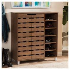 a wooden shoe cabinet with several pairs of shoes on it's shelves next to a coat rack