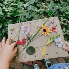 someone is holding a box with flowers on it and string attached to the outside wall