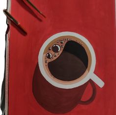 a drawing of a cup of coffee on a red surface with two pencils next to it