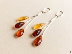 "Cherry, lemon and cognac colors amber earrings with silver for minimal jewelry admirers. Get these bright drop shape long amber earrings designed into a jewelry piece that catches every sight on the street! MATERIALS AND SIZE: Stone: 100% Natural Baltic Amber Other materials: silver 925 Weight: 5,2g (0,18 oz) Bead size: ~1,6 cm (0,62 in) x ~1 cm (0.39 in) Total earring length: ~8 cm (3,14 in) PLEASE NOTE: All our amber production is made of natural amber. Amber is an unique stone and every piec Baltic Amber Dangle Earrings, Teardrop Baltic Amber Earrings, Modern Amber Drop Earrings, Amber Resin, Golden Logo, Earring Dangle, Cognac Color, Amber Earrings, Natural Amber