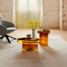 a modern living room with yellow flowers in the vase and two chairs on the floor