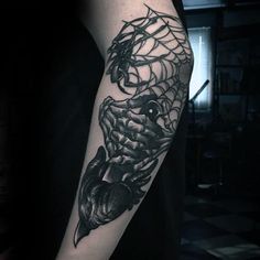 a black and white photo of a spider web tattoo on the left upper half of the arm