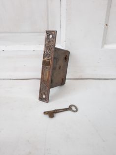 an old door handle with two keys on the floor