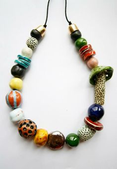 a multi colored beaded necklace on a white surface