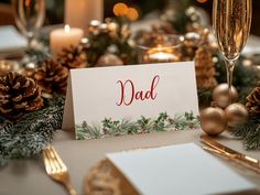 a christmas table setting with candles, pine cones and greeting cards that read'dad '