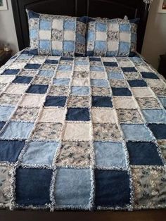 a bed with blue and white quilts on it