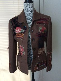 a brown jacket with flowers on it sitting on a mannequin