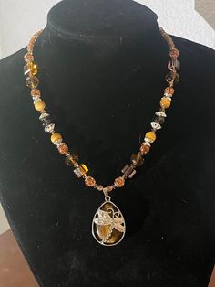 This 19-inch beaded necklace is made with varying hues of brown glass beads with silver-colored accents.  The 1.5-inch pendant is a tiger's eye teardrop with a silver-colored dragon fly. Beaded Teardrop Brown Necklace, Brown Beaded Teardrop Necklace, Brown Crystal Necklace With Faceted Beads For Gift, Brown Necklace With Silver Beads For Gift, Brown Beaded Necklace, Dragon Fly, Tiger's Eye, Tiger Eye, Necklace Etsy