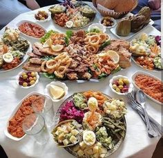 a table topped with lots of food and plates filled with different types of foods on top of it