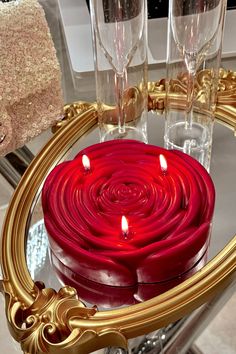 there is a red candle in the middle of a table with wine glasses on it