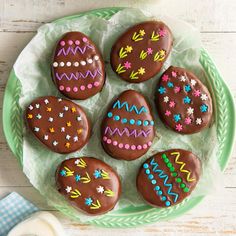 chocolate easter eggs decorated with colorful designs on a green plate