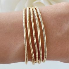 Attached layers Includes everything pictured Material: gold plated brass Length: 7" + 2" extension Gold Multi-strand Stackable Bracelets, Gold Metal Bracelets For Layering, Gold Flexible Snake Chain Bracelet, Gold Brass Stackable Bracelets, Gold Stackable Brass Bracelets, Adjustable Gold Bracelet For Layering, Adjustable Gold Snake Chain Bracelet, Gold Multi-strand Stackable Jewelry, Gold Plated Flexible Chain Bracelet