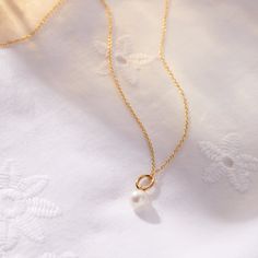 The Pearl Mini Charm Necklace embodies timeless elegance and the precious bond between mother and child. Just as a pearl grows in beauty over time, it serves as a graceful reminder of the love that strengthens with each passing moment. Wear it alone or layer it with your favorite Tiny Tags necklace for a look that’s both meaningful and chic. available in gold vermeil and sterling silver genuine pearl is 7mm hangs on diamond cut chain. View our necklace size guide here. Timeless Wedding Necklace With Pearl Charm, Everyday Pearl Charm Necklace For Mother's Day, Mother's Day Pearl Charm Jewelry, Mother's Day Round Pearl Charm Jewelry, Elegant Pearl Charm Necklaces, Pearl Necklace With Pearl Charm For Mother's Day, Timeless Pearl Necklace With Clavicle Chain As Gift, Elegant Pearl Charm Necklace, Timeless Pearl Necklace With Clavicle Chain