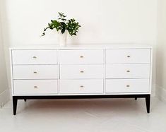 a white dresser with a plant on top