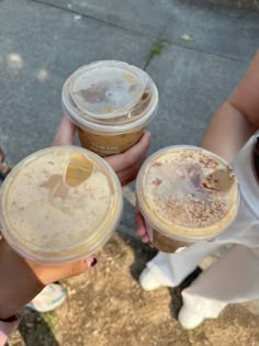 three people are holding up their drinks outside