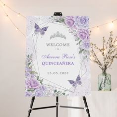 a welcome sign with purple flowers and butterflies in the frame is on an easel