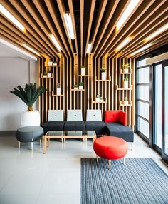 a living room filled with lots of furniture next to a large glass window covered in wooden slats